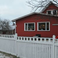 Furugården, rött hus med vitt staket runtomkring.