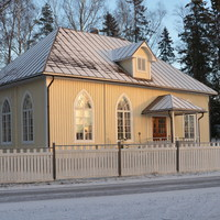Dagklubben i Västerby bönehus, gult hus speglas i vinterns solsken.
