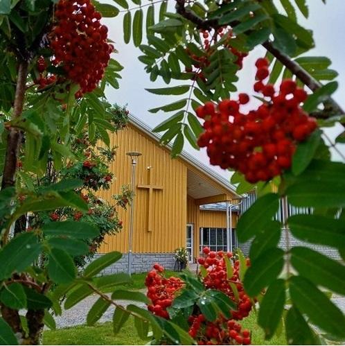 Larsmo församlingshem med rönnbärsträd i förgrunden